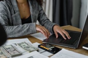 A woman creating a budget and reading the guide on how to find the best neighborhood for your lifestyle and budget